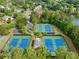 Aerial view of multiple community tennis courts surrounded by mature trees and lush landscaping at 1435 Harburn Ct, Cumming, GA 30041