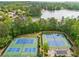 Overhead view of well-maintained community tennis courts near a tranquil lake setting at 1435 Harburn Ct, Cumming, GA 30041