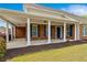 The back porch of this beautiful home features an exterior of brick, columns, and blue shutters at 2055 Hickory Station Cir, Snellville, GA 30078