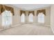 Bright bedroom featuring three large windows with decorative valances and neutral carpeting at 2055 Hickory Station Cir, Snellville, GA 30078