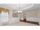 Bright dining room featuring wainscoting, decorative chandelier and access to other rooms at 2055 Hickory Station Cir, Snellville, GA 30078