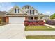 Charming two-story home featuring a brick and tan exterior with a two-car garage and manicured front yard at 2055 Hickory Station Cir, Snellville, GA 30078