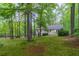 Beautifully landscaped backyard with mature trees and a well-maintained lawn at 607 Hickory Creek Ln, Woodstock, GA 30188