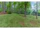 Expansive backyard with lush green grass, mature trees, and a serene, private setting at 607 Hickory Creek Ln, Woodstock, GA 30188