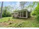 A rear view shows the screened-in porch of this charming home, set in a lush, green backyard at 980 Oakton Sw Dr, Marietta, GA 30060