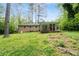 A rear view of the house showing the screened in porch, brick exterior, and expansive backyard at 980 Oakton Sw Dr, Marietta, GA 30060