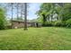 A rear view of the house showing the screened in porch, brick exterior, and expansive backyard at 980 Oakton Sw Dr, Marietta, GA 30060