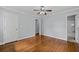 A bedroom with hardwood floors, gray walls, white doors, and an open doorway to the bathroom at 980 Oakton Sw Dr, Marietta, GA 30060