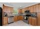 A well-lit kitchen boasting stainless steel appliances, wood cabinets, and tiled floors at 980 Oakton Sw Dr, Marietta, GA 30060