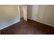 View of a simple bedroom with hardwood floors and two doors with an open closet at 2888 Mountain View Rd, Snellville, GA 30078