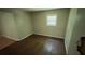 A simple bedroom features a window providing natural light and beautiful hardwood floors at 2888 Mountain View Rd, Snellville, GA 30078