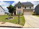 Inviting brick home showcasing a two-car garage and a landscaped yard with a tree at 4935 Bellehurst Ln, Cumming, GA 30040