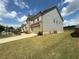 A beautiful side view of a home with an attached garage, well-maintained lawn, and colorful landscaping at 4935 Bellehurst Ln, Cumming, GA 30040