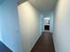 Hallway leading to a bathroom with hardwood floors and white walls at 4935 Bellehurst Ln, Cumming, GA 30040