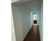 Hallway leading to a bathroom with hardwood floors and white walls at 4935 Bellehurst Ln, Cumming, GA 30040