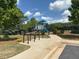 Playground featuring new equipment, a black fence surround and benches at 4935 Bellehurst Ln, Cumming, GA 30040
