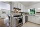 Open kitchen with white cabinets, stainless steel appliances, and view into dining room at 4311 N Elizabeth Se Ln, Atlanta, GA 30339
