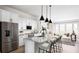 Modern kitchen with white cabinets, stainless steel appliances, and a marble countertop island with pendant lighting at 506 Motivation Nw Cir, Atlanta, GA 30309
