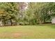 Expansive backyard with lush lawn and mature trees at 228 Amour Sw Way, Lilburn, GA 30047