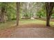 The backyard features a patio, grassy area, and mature trees and storage shed at 228 Amour Sw Way, Lilburn, GA 30047