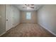 Standard bedroom features wall-to-wall carpeting, ceiling fan, and closet door at 228 Amour Sw Way, Lilburn, GA 30047