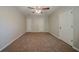 Neutral bedroom features wall-to-wall carpeting, ceiling fan, and two entry doors at 228 Amour Sw Way, Lilburn, GA 30047