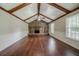 Spacious living room with wood floors, stone fireplace, ceiling fan, and exposed wood beams at 228 Amour Sw Way, Lilburn, GA 30047