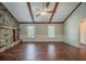 Large living room with stone fireplace, wood flooring, exposed beams, and bright windows at 228 Amour Sw Way, Lilburn, GA 30047