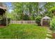 Fenced backyard featuring lush green grass and a storage shed with trees in the background at 2871 Parkridge Ne, Brookhaven, GA 30319
