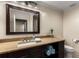 Bathroom vanity featuring neutral granite countertop, wood cabinets, framed mirror, and ceramic tile flooring at 2871 Parkridge Ne, Brookhaven, GA 30319
