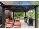 Covered outdoor seating area features comfortable chairs, ottomans, and a stainless steel grill at 2871 Parkridge Ne, Brookhaven, GA 30319