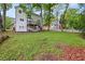 Spacious backyard with a wooden deck, surrounded by mature trees and lush greenery at 3270 Golfe Links Dr, Snellville, GA 30039