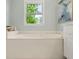 Relaxing bathroom with a large soaking tub near a window with a lush green view at 3270 Golfe Links Dr, Snellville, GA 30039