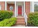 Inviting front entry featuring a red door, brick facade, and lush landscaping at 3270 Golfe Links Dr, Snellville, GA 30039