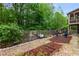 Landscaped backyard with stone paths, seating, garden beds, wooden fence, and direct access to house at 4876 Briarcliff Dr, Sugar Hill, GA 30518