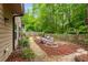 Picturesque backyard with stone pathway, landscaping, comfortable chairs near a fire pit and wooded surround at 4876 Briarcliff Dr, Sugar Hill, GA 30518