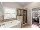 Well-lit bathroom showcasing a tub and a glass-enclosed shower, offering a spa-like experience at 4876 Briarcliff Dr, Sugar Hill, GA 30518