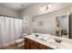 Bright bathroom featuring double sinks, wood cabinets, shower with tub, and large mirror at 4876 Briarcliff Dr, Sugar Hill, GA 30518
