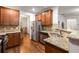 Open kitchen with stainless steel appliances, granite counters, hardwood floors, and adjacent dining space at 4876 Briarcliff Dr, Sugar Hill, GA 30518