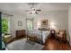 Spacious main bedroom with hardwood floors, ceiling fan, and plenty of natural light from the many windows at 4876 Briarcliff Dr, Sugar Hill, GA 30518