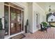 Inviting covered front porch with brick flooring, comfortable seating, and a charming glass-paneled front door at 1021 Bluffhaven Ne Way, Atlanta, GA 30319