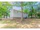 View of the back of the home with a large tree-filled backyard at 1051 S Millard Way, Stone Mountain, GA 30088