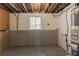Unfinished basement with window, concrete floor and walls, and exposed ceiling at 1051 S Millard Way, Stone Mountain, GA 30088
