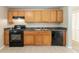 Functional kitchen featuring wood cabinets, a black gas range, and modern appliances at 1051 S Millard Way, Stone Mountain, GA 30088