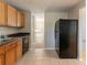 Efficient kitchen layout featuring wood cabinets, black appliances, and tile flooring at 1051 S Millard Way, Stone Mountain, GA 30088