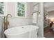 Elegant bathroom featuring a standalone tub, marble tile, and brass fixtures at 1911 Rollingwood Se Dr, Atlanta, GA 30316