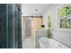 Luxurious bathroom with a glass shower, soaking tub, wood-look tile and modern fixtures at 1911 Rollingwood Se Dr, Atlanta, GA 30316