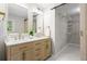 Modern bathroom featuring double sinks, wood cabinets, gold fixtures, and a walk-in closet with sliding barn door at 1911 Rollingwood Se Dr, Atlanta, GA 30316