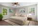Bright bedroom featuring a queen-sized bed, neutral decor, wood floors, two windows, and modern ceiling fan at 1911 Rollingwood Se Dr, Atlanta, GA 30316