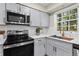 Close up of the modern kitchen with gray cabinets, stainless steel appliances, quartz counters, and new hardware at 1911 Rollingwood Se Dr, Atlanta, GA 30316